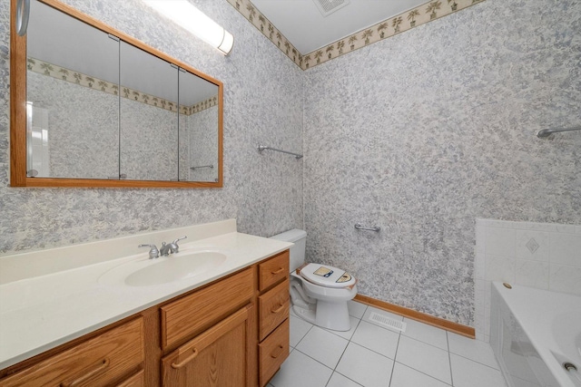 bathroom with tile patterned flooring, vanity, toilet, and a bathtub