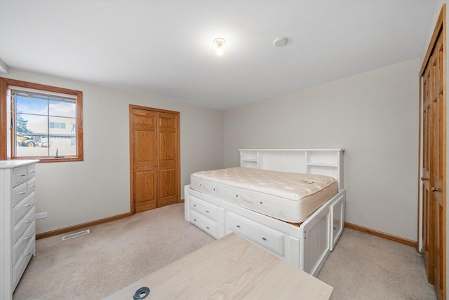 bedroom featuring light carpet and a closet