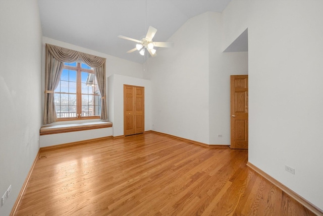 empty room featuring ceiling fan, light hardwood / wood-style floors, and high vaulted ceiling