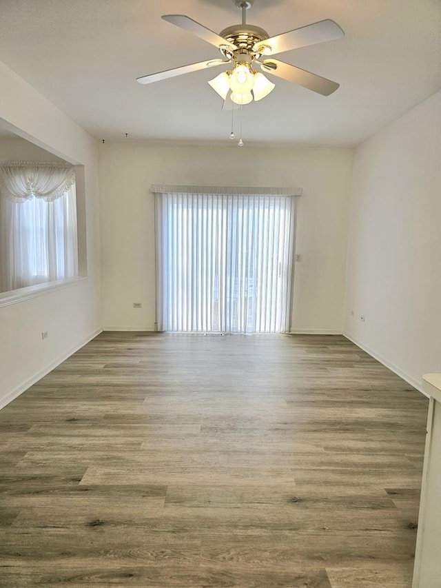 unfurnished room with ceiling fan and hardwood / wood-style flooring