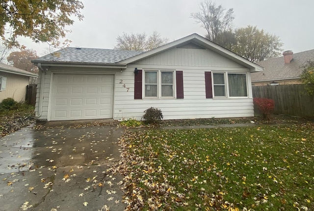 ranch-style home with concrete driveway, roof with shingles, an attached garage, fence, and a front yard