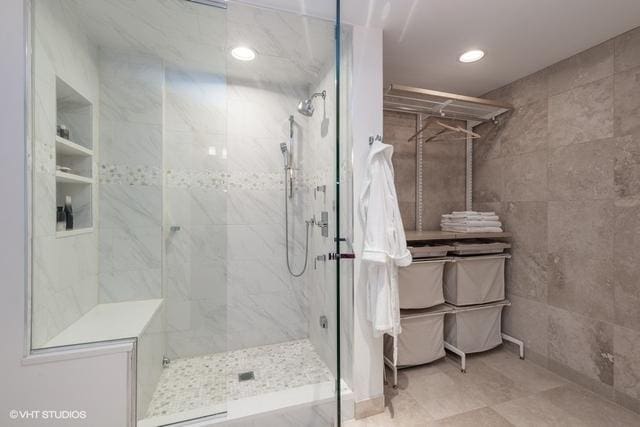 bathroom featuring tile walls and a tile shower