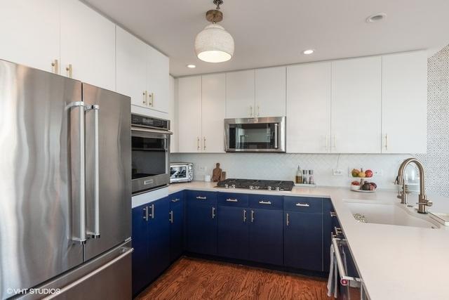 kitchen featuring appliances with stainless steel finishes, sink, blue cabinetry, white cabinets, and hanging light fixtures