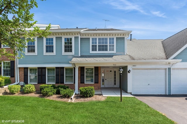 view of front of property featuring a front yard and a garage