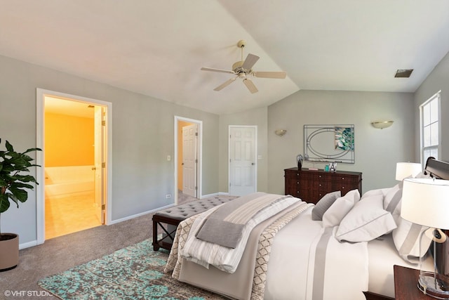 bedroom featuring ceiling fan, carpet floors, ensuite bathroom, and vaulted ceiling