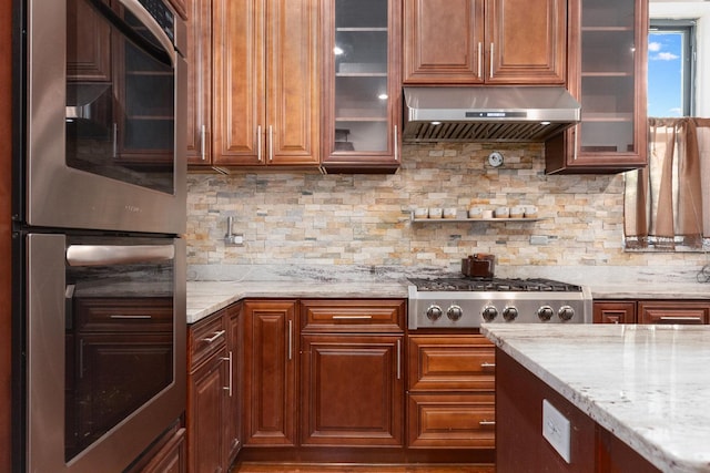 kitchen with decorative backsplash, light stone countertops, and appliances with stainless steel finishes