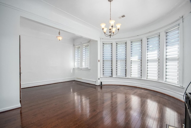 unfurnished room with a chandelier, dark hardwood / wood-style flooring, and plenty of natural light