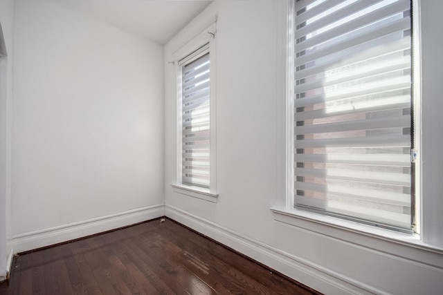 spare room featuring plenty of natural light and dark hardwood / wood-style floors