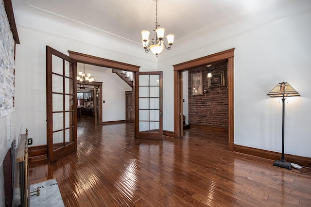 unfurnished dining area with french doors, dark wood-type flooring, and a notable chandelier