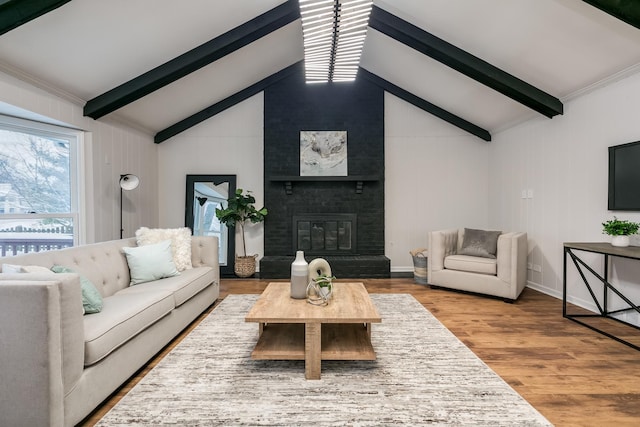 living room featuring a fireplace, lofted ceiling with beams, and hardwood / wood-style flooring