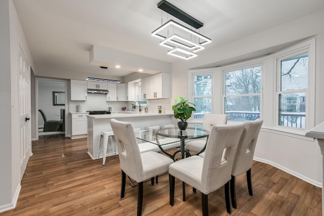 dining area featuring dark hardwood / wood-style flooring, a chandelier, and sink