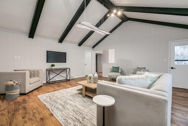 living room with wooden walls, lofted ceiling with beams, and hardwood / wood-style flooring