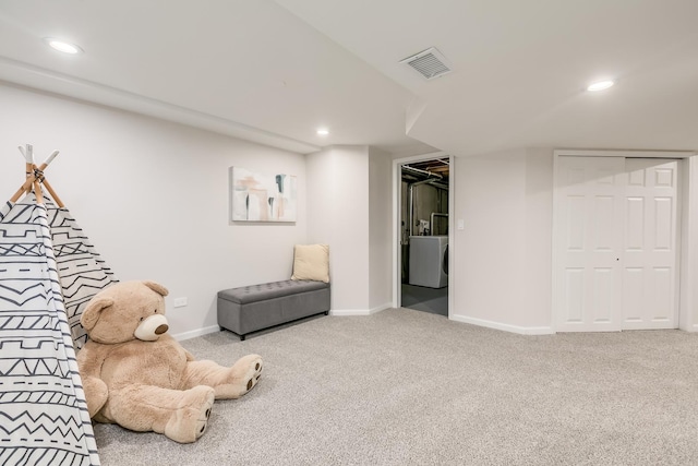 living area featuring washer / dryer and carpet floors