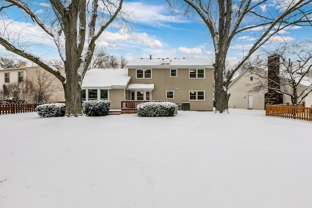 snow covered rear of property with cooling unit and a deck