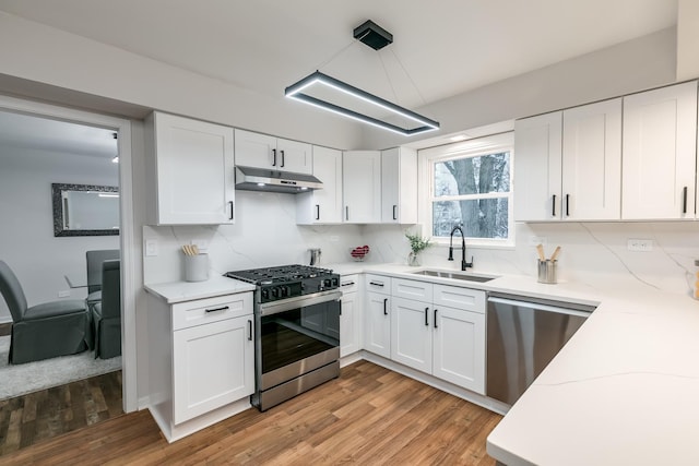 kitchen featuring sink, white cabinets, stainless steel appliances, and light hardwood / wood-style floors