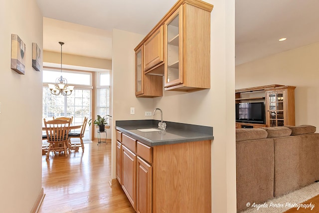 kitchen with a chandelier, decorative light fixtures, light hardwood / wood-style flooring, and sink