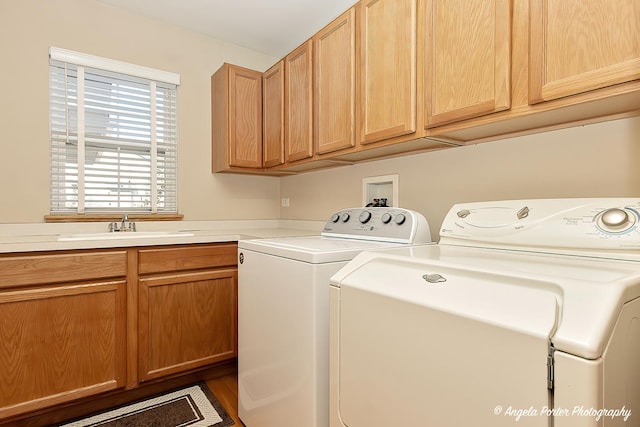 laundry room featuring cabinets, independent washer and dryer, and sink