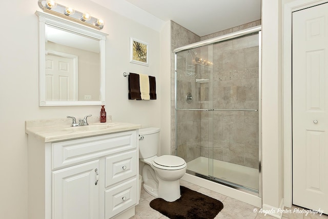 bathroom with tile patterned flooring, vanity, toilet, and a shower with door