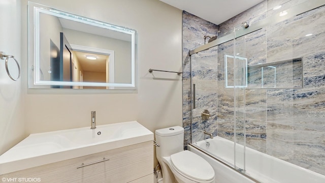 full bathroom featuring toilet, combined bath / shower with glass door, and vanity