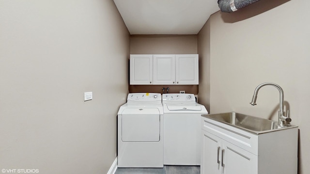 washroom with sink, cabinets, and independent washer and dryer