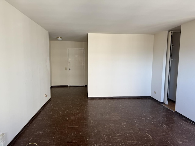 unfurnished room with dark parquet flooring