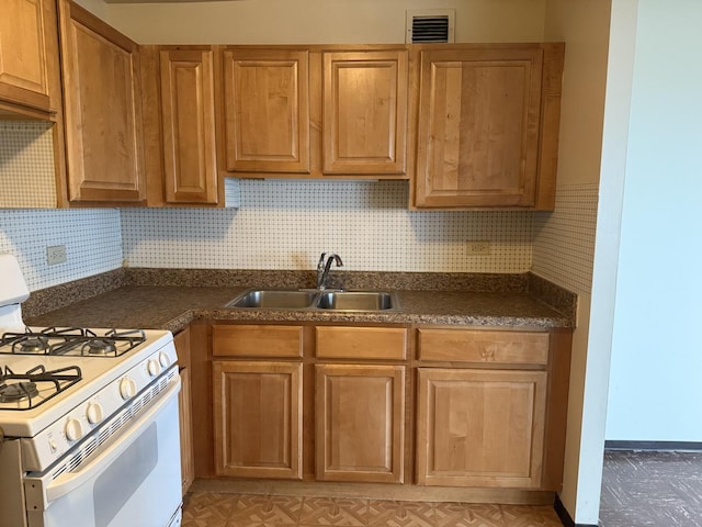 kitchen with tasteful backsplash, sink, and gas range gas stove