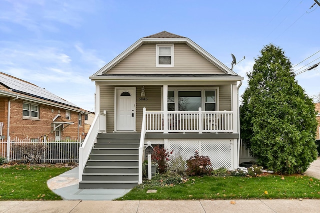 bungalow with a front yard and covered porch