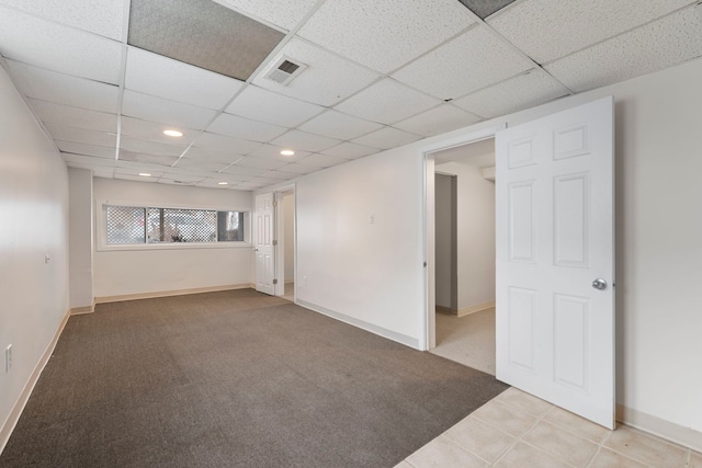 carpeted spare room with a drop ceiling