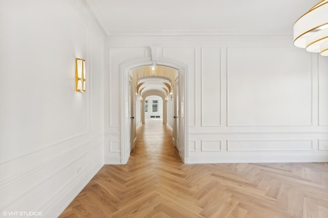 hall with light parquet flooring and crown molding