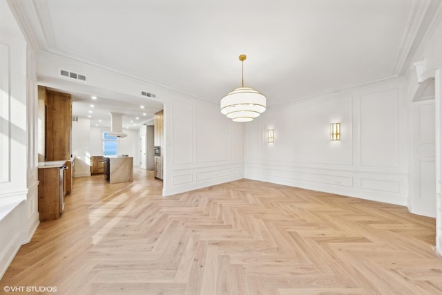 unfurnished dining area with crown molding and light parquet flooring