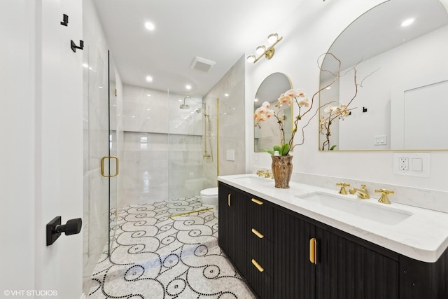 bathroom with a shower with door, vanity, and toilet