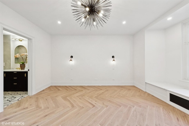 unfurnished room featuring light parquet floors and a notable chandelier