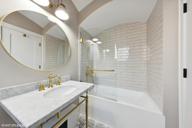 bathroom featuring shower / bath combination with glass door, vanity, and vaulted ceiling