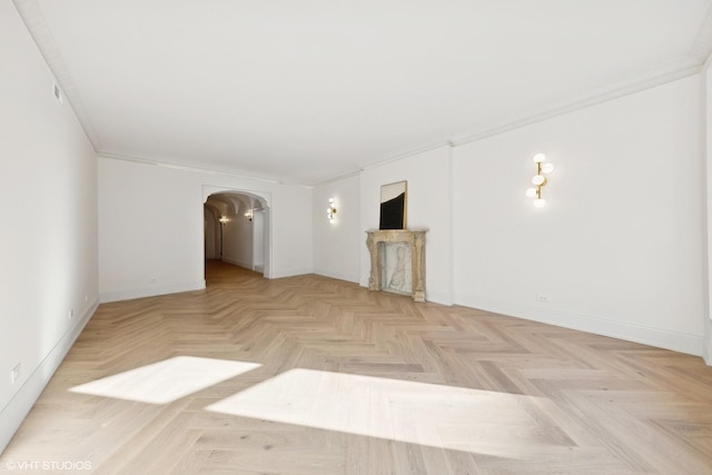 unfurnished living room featuring crown molding and light parquet flooring