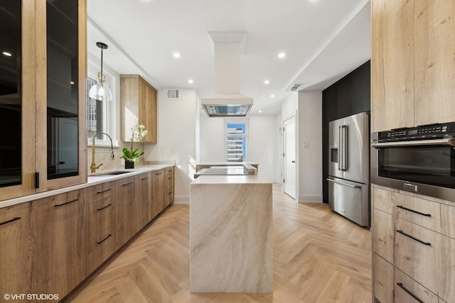 kitchen featuring appliances with stainless steel finishes, light parquet flooring, pendant lighting, and sink