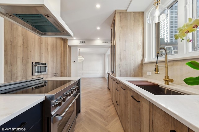 kitchen with appliances with stainless steel finishes, exhaust hood, sink, decorative light fixtures, and light parquet flooring