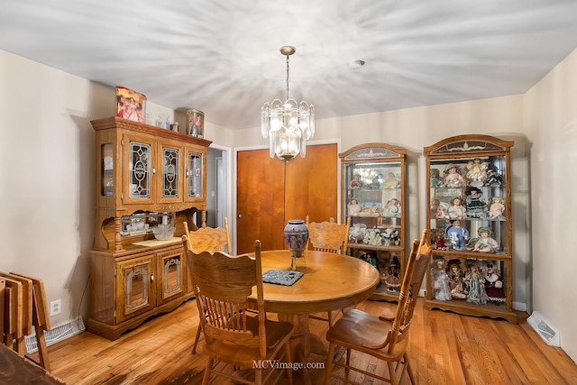 dining space featuring light hardwood / wood-style floors and a notable chandelier