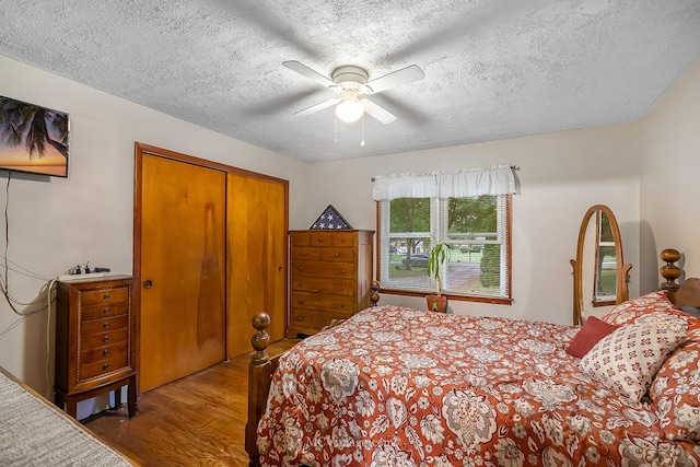 bedroom featuring ceiling fan, a closet, a textured ceiling, and hardwood / wood-style flooring