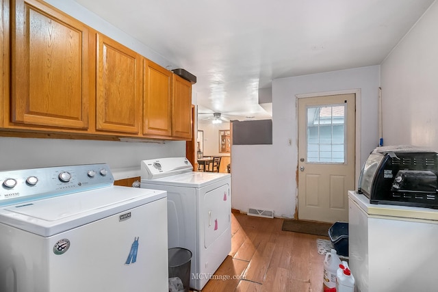 washroom featuring ceiling fan, light hardwood / wood-style floors, cabinets, and washing machine and dryer