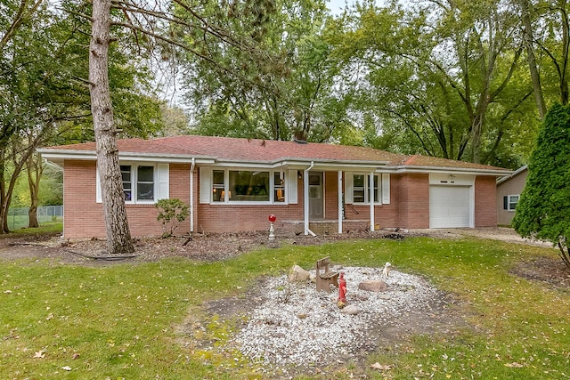 ranch-style home with covered porch, a garage, and a front yard