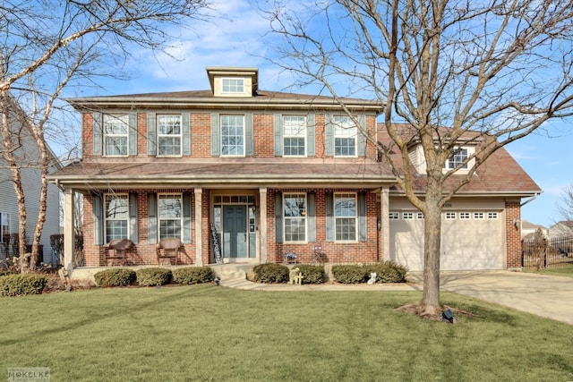 view of front of house with a front yard, an attached garage, covered porch, and driveway