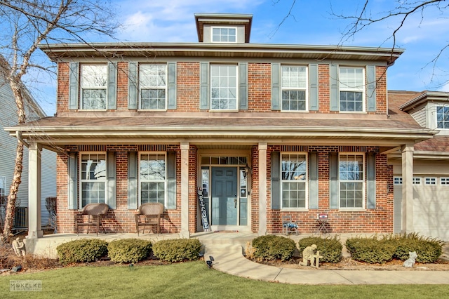 view of front facade featuring a garage, brick siding, and covered porch