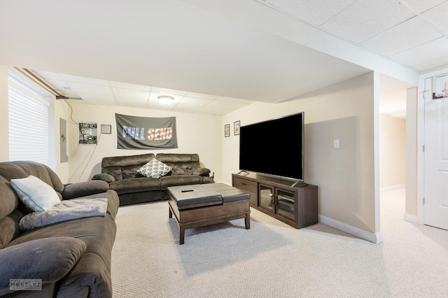 living room with carpet flooring, baseboards, and a drop ceiling