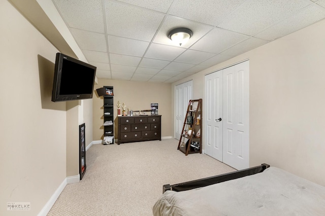 bedroom with a drop ceiling, baseboards, and carpet