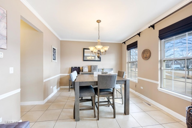 dining area featuring light tile patterned floors, baseboards, visible vents, an inviting chandelier, and ornamental molding