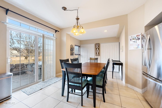 dining space featuring a notable chandelier, light tile patterned floors, and baseboards