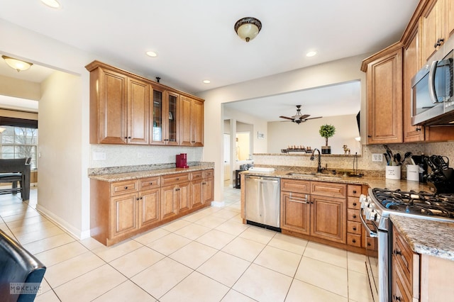 kitchen featuring a sink, decorative backsplash, brown cabinets, and stainless steel appliances