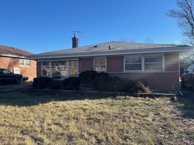 rear view of house featuring a lawn