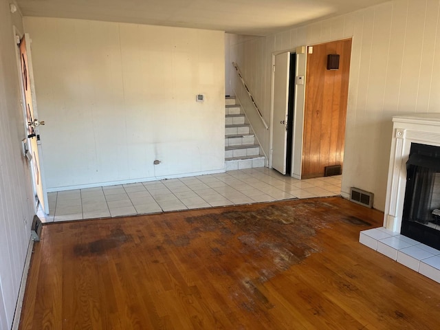 unfurnished living room with a fireplace and light wood-type flooring