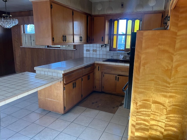 kitchen featuring tile countertops, light tile patterned floors, sink, and tasteful backsplash